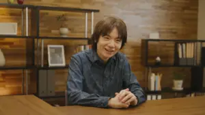 Masahiro Sakurai souriant lors d'une présentation officielle de ses jeux vidéo